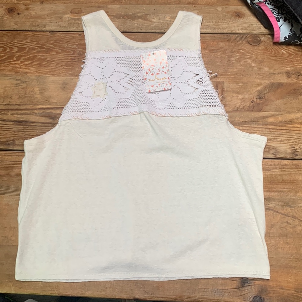 An ivory colored tshirt that has knitted pattern on the chest.